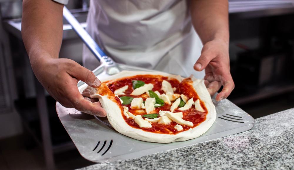 Dos delicias universales en una: hoy se celebra el día del pizzero empanadero